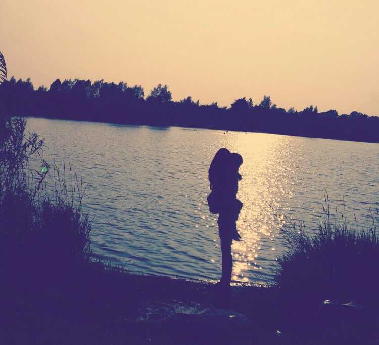 Девушка у реки со спины