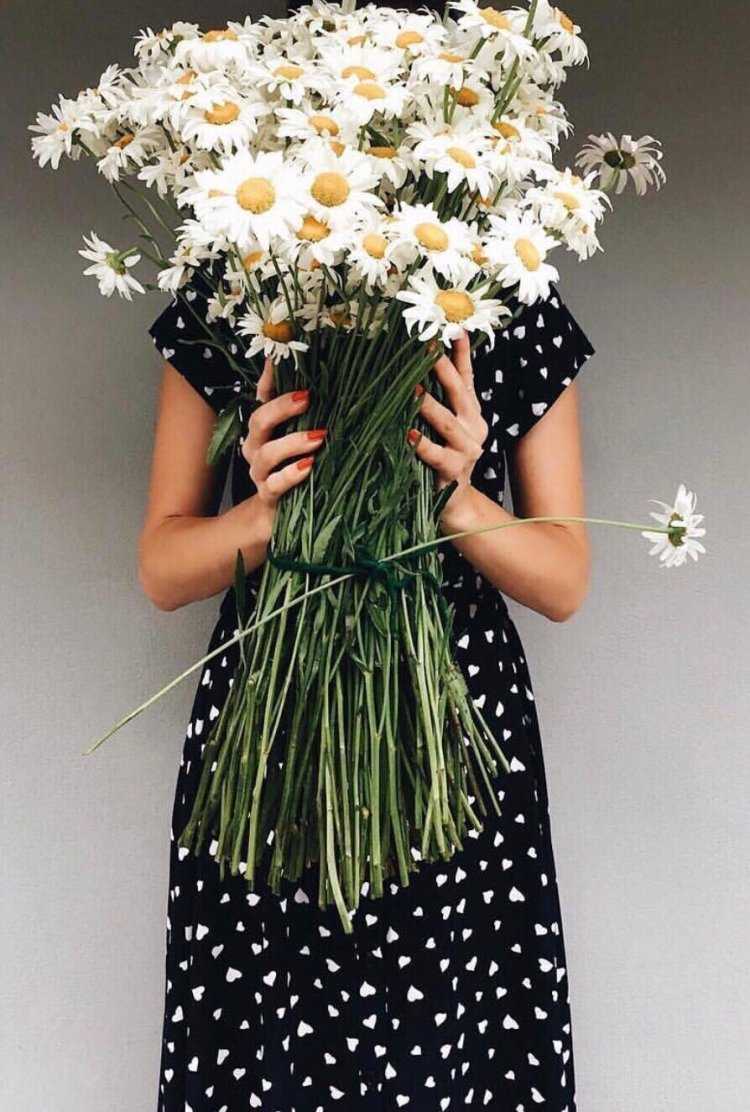 Брюнетка с букетом ромашек