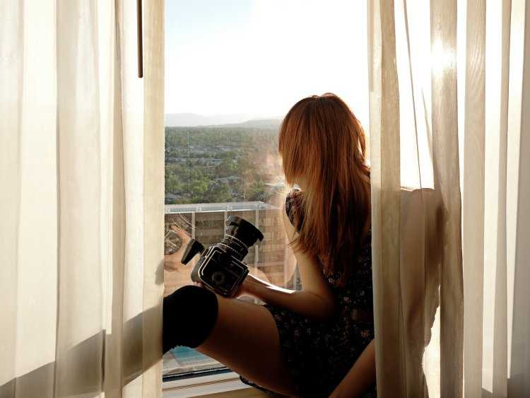 Рыжая девушка у окна