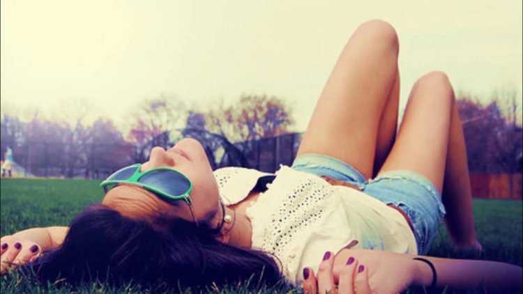 Игривая брюнетка принимает соблазнительную позу на зеленом покрывале