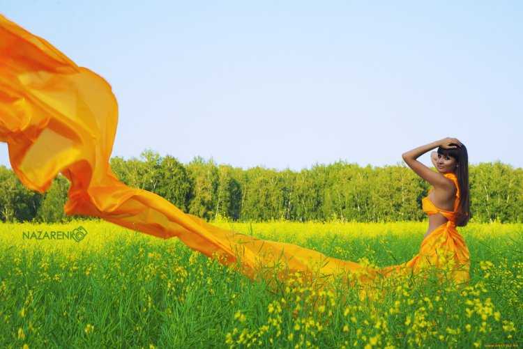 Искусительная девушка в оранжевом платье на природе