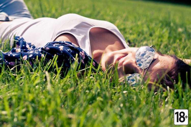 Девушка в траве со спины