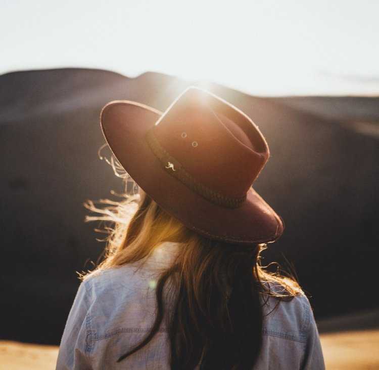 Девушка в черной шляпе со спины