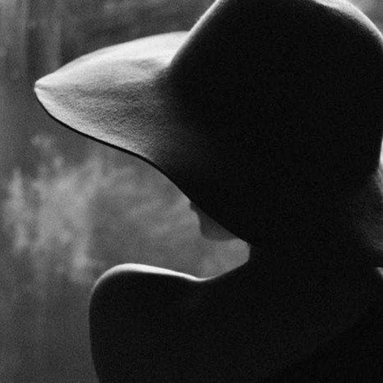 Девушка в черной шляпе со спины