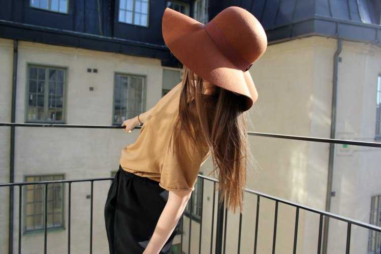 Девушка прикрывается шляпой