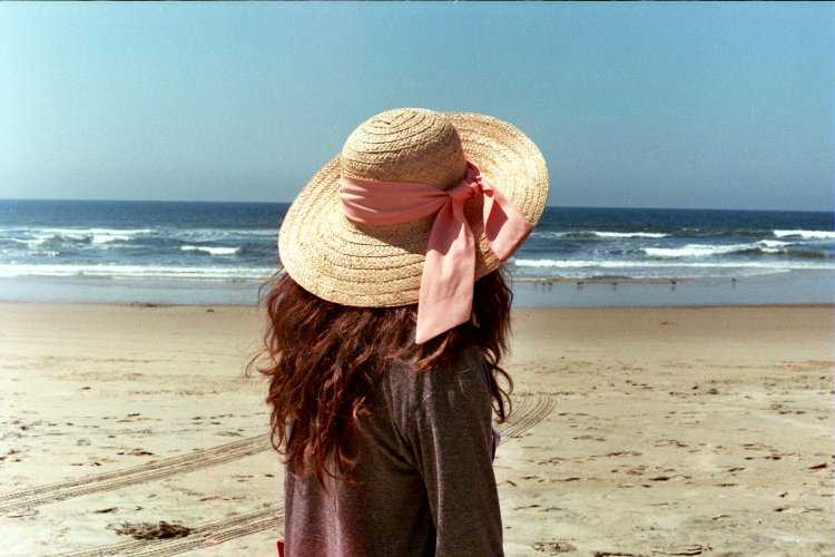 Русая в шляпе на море