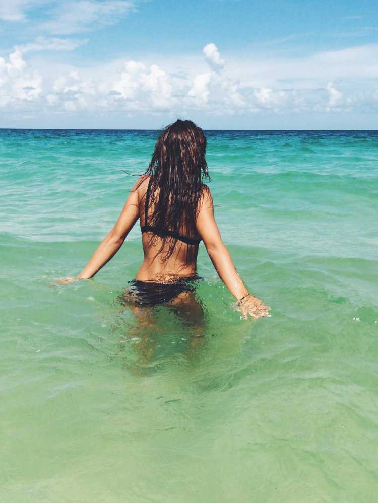 Брюнетка на море со спины