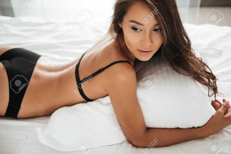 Красивая маленькая азиатка в Цветном Нижнем белье лежа