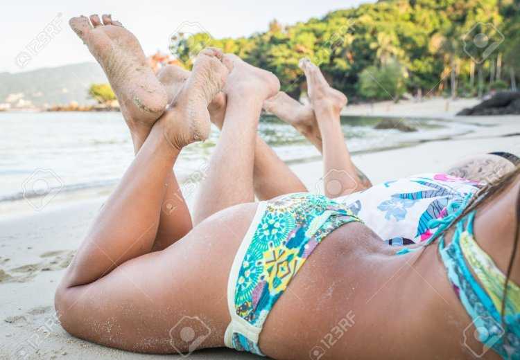 Девушка на пляже скрестив ноги